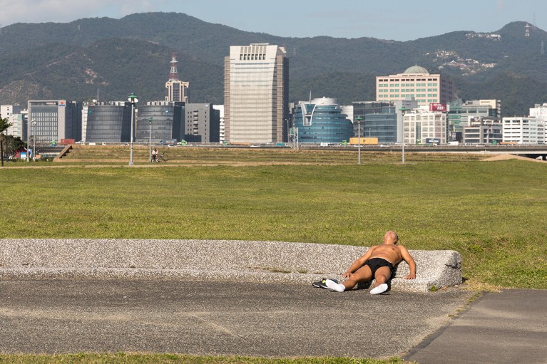 Ένας τόπλες αρσενικός jogger βρίσκεται στο UB τον ήλιο κατά τη διάρκεια ενός καραβάκι στην Ταϊπέι της Ταϊβάν.